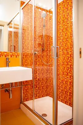 a shower with a glass door next to a sink at Domus Colosseum by JFM - Cozy apartment nearby Colosseum in Rome
