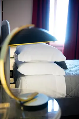 a bed with white pillows and a table with a mirror at Myway RDR Apartment in Rome