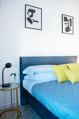 a bedroom with a blue bed and a side table at Myway RDR Apartment in Rome