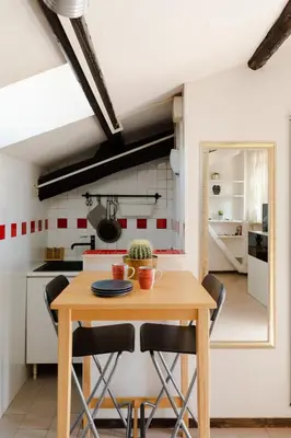 a kitchen with a wooden table and chairs at La mansarda del Papa - ZENO 05 in Rome