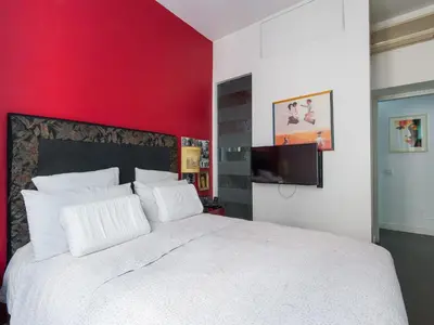a bedroom with a white bed with a red wall at Apartment San Salvatore by Interhome in Rome