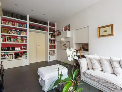 a living room with a white couch and bookshelves at Apartment San Salvatore by Interhome in Rome