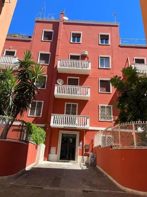 a red building with white balconies on a street at Red house in Monteverde - Cale 02 in Rome