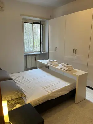 a bedroom with a bed with a desk and a window at Red house in Monteverde - Cale 02 in Rome