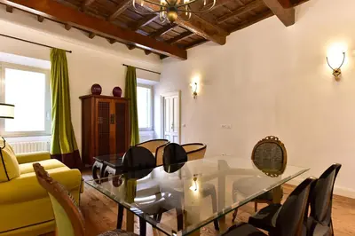 a living room with a glass table and chairs at Residenza Clodio Spanish Steps in Rome