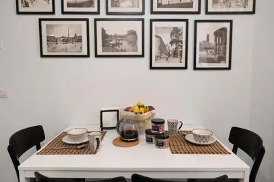 a dining room table with a bowl of fruit and pictures on the wall at Veniero37 Guest House in Rome