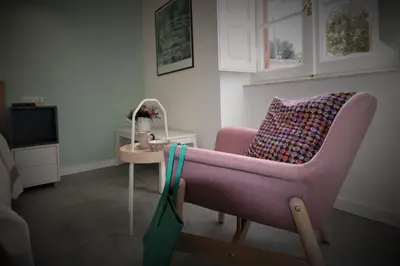 a living room with a pink chair and a table at Veniero37 Guest House in Rome