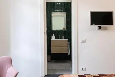 a room with a bathroom with a television and a mirror at Veniero37 Guest House in Rome