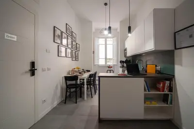 a kitchen with white cabinets and a table with chairs at Veniero37 Guest House in Rome