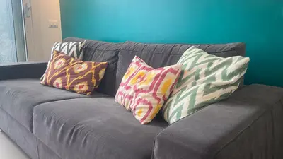 four pillows on a gray couch in a living room at GreenSpace Romantic Studio - Piazza del Popolo in Rome