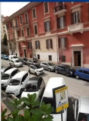 a row of cars parked in a parking lot next to a building at Lovely Suite accogliente appartamento tra Policlinico e Piazza Bologna in Rome