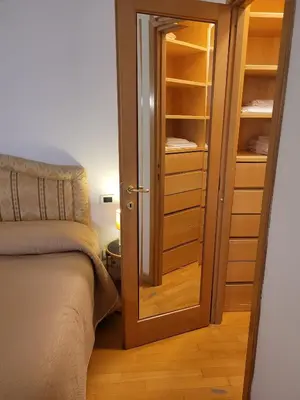 a room with a bed and a closet with a glass door at Lovely Suite accogliente appartamento tra Policlinico e Piazza Bologna in Rome