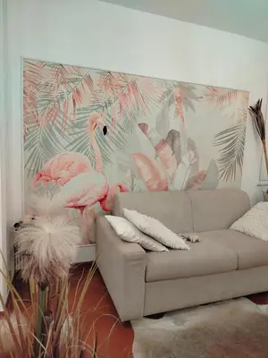 a living room with a couch and a mural of flamingos at Casina Tiberina Suite in Rome