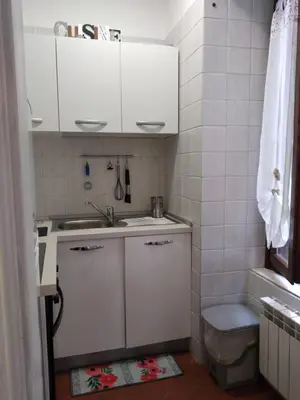 a small kitchen with white cabinets and a sink at Casina Tiberina Suite in Rome