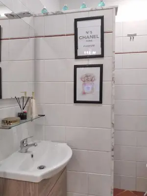a bathroom with a sink and two pictures on the wall at Casina Tiberina Suite in Rome