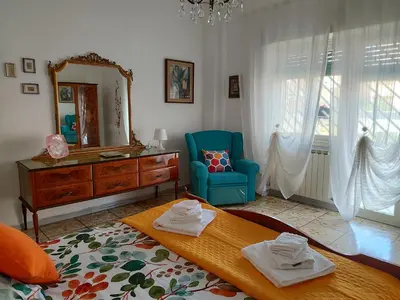 a living room with a blue chair and a mirror at Astmigo in Rome