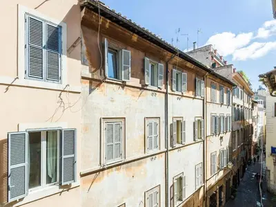 an old building with shuttered windows on a street at Apartment in a 1400s building in Via dei Coronari Piazza Navona in Rome
