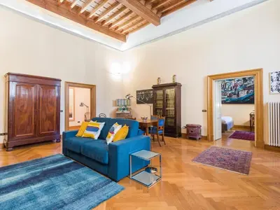 a living room with a blue couch and a table at Apartment in a 1400s building in Via dei Coronari Piazza Navona in Rome