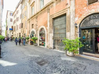 a group of people walking down a street next to buildings at Apartment in a 1400s building in Via dei Coronari Piazza Navona in Rome