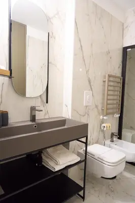 a bathroom with a sink and a toilet and a mirror at Trastevere Boutique with Gym and Steam Shower in Rome