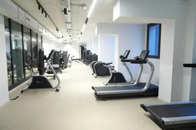 a gym with several treadmills and elliptical machines at Trastevere Boutique with Gym and Steam Shower in Rome