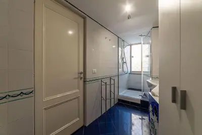 a bathroom with a white door and a blue tile floor at HospitalityRome Piazza di Spagna View in Rome
