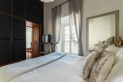 a bedroom with a large white bed with a mirror at HospitalityRome Piazza di Spagna View in Rome