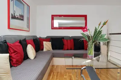 a living room with a gray couch with red pillows at Design accommodation in Rome