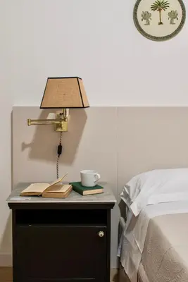a lamp on a table next to a bed at RELAIS DEI GOTI in Rome