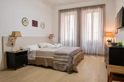 a bedroom with a bed and a dresser and a television at RELAIS DEI GOTI in Rome