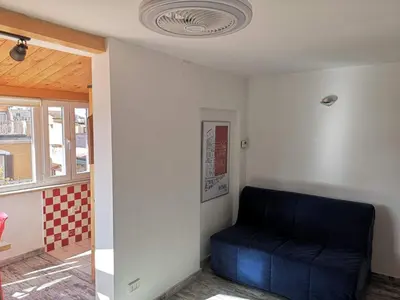 a blue couch sitting in a corner of a room at Soulmate Rooftop Apartment in Rome