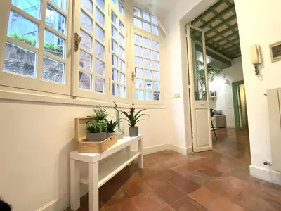 a hallway with windows and a table with plants on it at Pantheon Ancient Rome Apartment in Rome