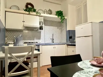a kitchen with white cabinets and a table at Pantheon Ancient Rome Apartment in Rome