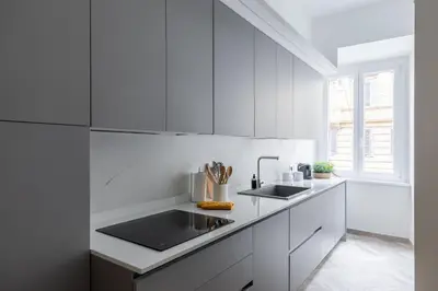 a white kitchen with white cabinets and a sink at iFlat Vatican Elegant Apartment in Rome