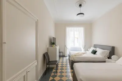a hotel room with two beds and a chair at iFlat Vatican Elegant Apartment in Rome