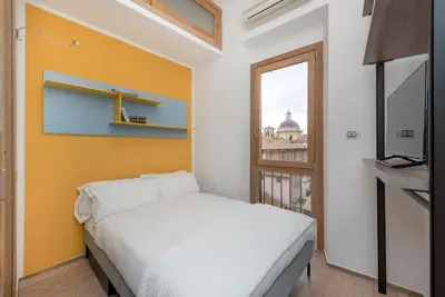 a bedroom with a white bed and a window at Modern Colosseum Flat in Rome