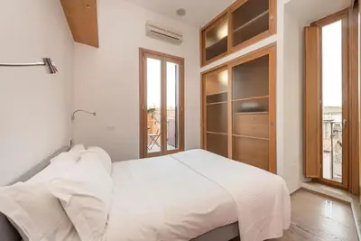 a white bedroom with a large bed and a window at Modern Colosseum Flat in Rome