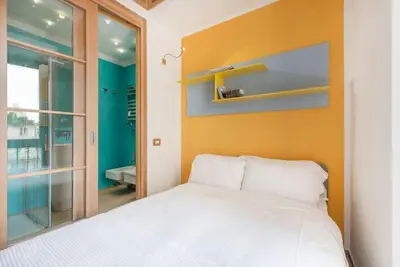 a bedroom with a white bed and a yellow wall at Modern Colosseum Flat in Rome