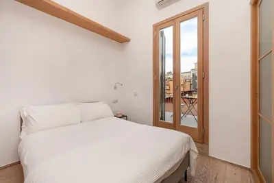 a white bed in a room with a window at Modern Colosseum Flat in Rome