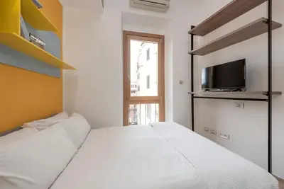 a bedroom with two beds and a tv and a window at Modern Colosseum Flat in Rome
