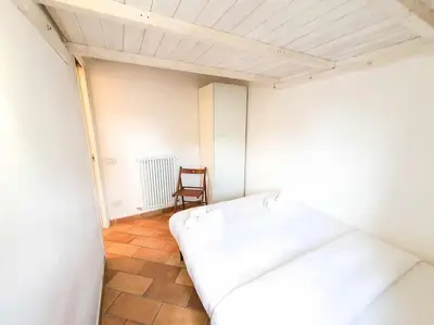 a small room with a bed and a chair at Cozy Apartment in Pigneto up to 4 in Rome