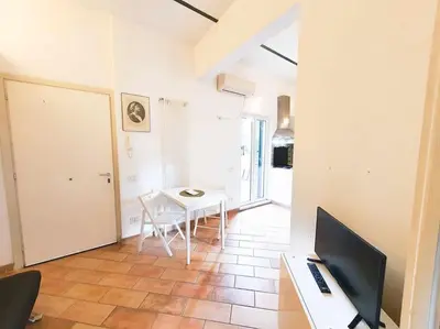 a living room with a table and a television at Cozy Apartment in Pigneto up to 4 in Rome
