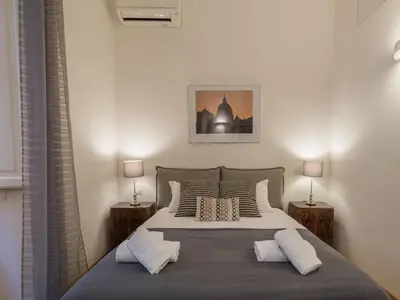 a bedroom with a large bed with two lamps at The Best Rent - Elegant flat near Colosseum in Rome