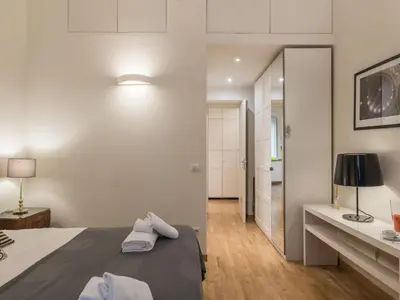 a bedroom with white walls and a bed and a mirror at The Best Rent - Elegant flat near Colosseum in Rome
