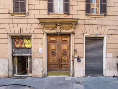 a building with a wooden door and two windows at The Best Rent - Elegant flat near Colosseum in Rome