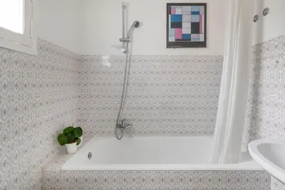 a bathroom with a bath tub and a sink at Bright Penthouse Downtown in Rome
