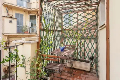 a patio with a wooden bench on a balcony at Bright Penthouse Downtown in Rome