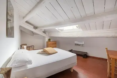 a bedroom with a large white bed and a table at Bright Penthouse Downtown in Rome