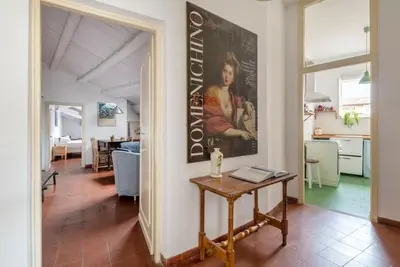 a living room with a table and a painting on the wall at Bright Penthouse Downtown in Rome