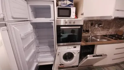 a kitchen with an open refrigerator with a washer and dryer at Appartamento Fiore Roma San Pietro in Rome